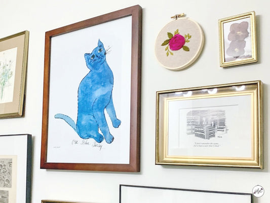 Rose embroidery hoop art displayed on a gallery wall in a home