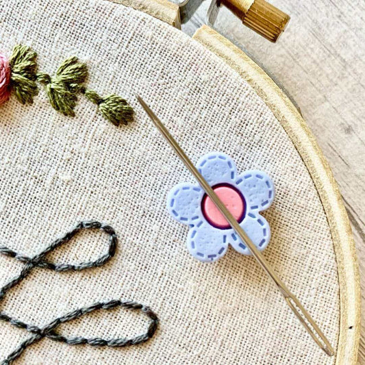 A daisy needle minder holding an embroidery needle