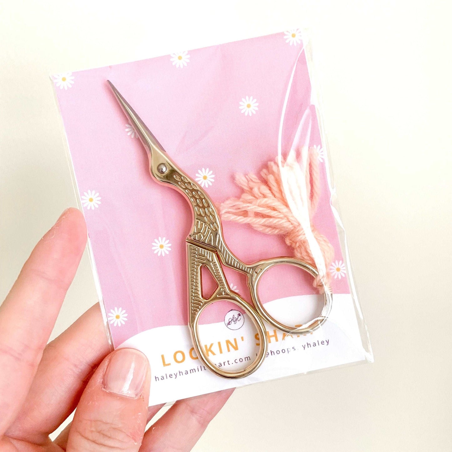 Hand holding gold bird embroidery scissors